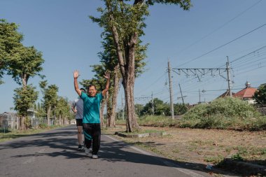 Bir koşucu hayat ve enerji dolu canlı bir şehir caddesinde sabah egzersizinden zevk alır.