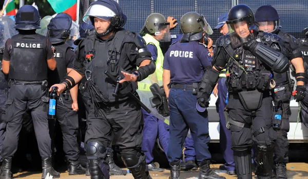 2 Eylül 2020 'de Bulgaristan' ın Sofya kenti: Ağır silahlı polis memurları, hükümet karşıtı protestoculardan biber gazı şişeleri ve çiçekler püskürtüyor