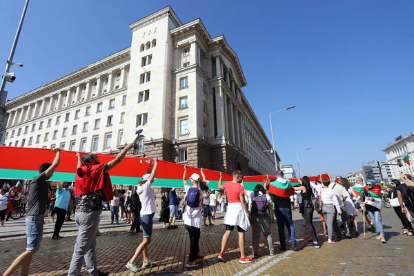 10 Eylül, Sofya, Bulgaristan: Mafya, hükümet ve Başsavcı İvan Geshev 'e karşı düzenlenen 64. protesto günü. İnsanlar kurumların önündeki Bulgar bayrağını açıyor.