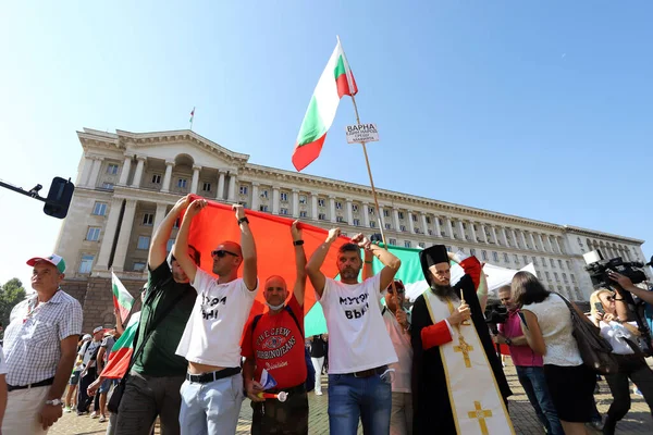 10 Eylül, Sofya, Bulgaristan: Mafya, hükümet ve Başsavcı İvan Geshev 'e karşı düzenlenen 64. protesto günü. İnsanlar kurumların önündeki Bulgar bayrağını açıyor.
