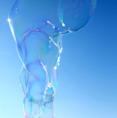 Brighton Plajı bir kabarcık değnek ile asa dan büyük büyük bir kabarcık duran bir kontrast adam gökyüzünde yüzen arkasında Brightons West Pier, gökyüzü arkasında parlak mavi, kabarcık şeffaf ama renkler yansıtan 