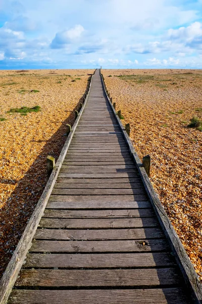 Lungo sentiero rettilineo in legno sulla spiaggia di ghiaia — Foto Stock