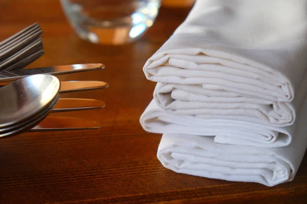 Close up de facas, garfos e colher com guardanapos em um restaurante — Fotografia de Stock
