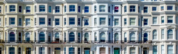 En rad engelska regentskap terrasserade fyra våningar hus, Brighton, Stockbild