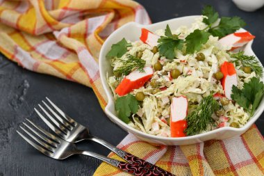 Çin lahanası, konserve bezelye ve yengeç ile sağlıklı salata bir kase karanlık bir arka plan sopa