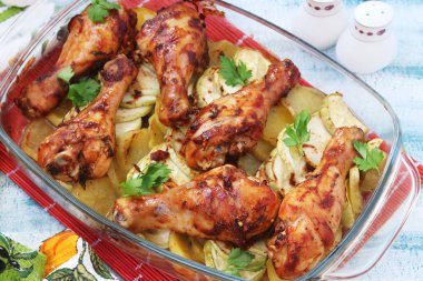 Patates ve kabak cam form ile pişmiş tavuk baget. Çatal, bıçak ve tuz ve biber kavanoz fotoğrafı vardır