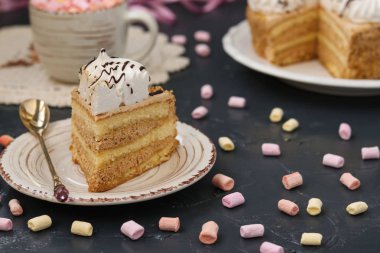 Karanlık bir arka plan üzerinde bulunan tereyağı krema ile sünger kek tatlım. Çok kolay bir plaka üzerinde ön planda