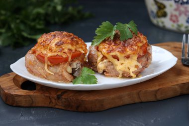 Domates ve peynirle bir ahşap tahta bir tabakta düzenlenmiş tavuk uyluk