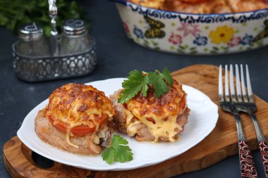 Domates ve peynirle bir ahşap tahta bir tabakta düzenlenmiş tavuk uyluk