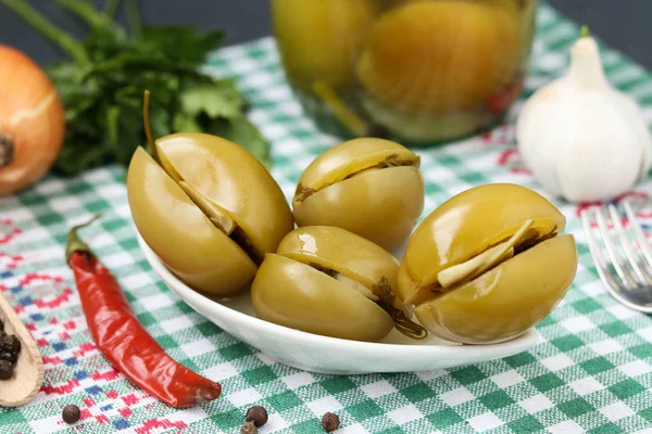 Bir tabak ve bir kavanoz masanın üzerinde Marine dolma yeşil domates
