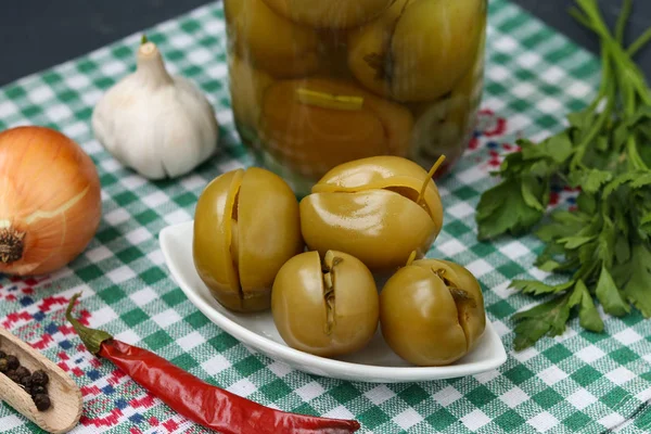 Bir tabak ve bir kavanoz masanın üzerinde Marine dolma yeşil domates