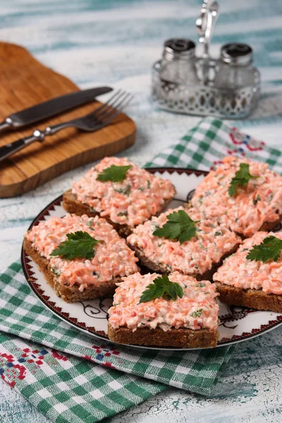 Sandvișuri cu bețe de crab și morcovi pe o farfurie pe un fundal albastru — Fotografie, imagine de stoc