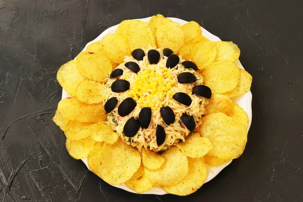 Salată sub formă de floarea-soarelui, decorată cu chipsuri de cartofi situate pe un fundal întunecat — Fotografie, imagine de stoc