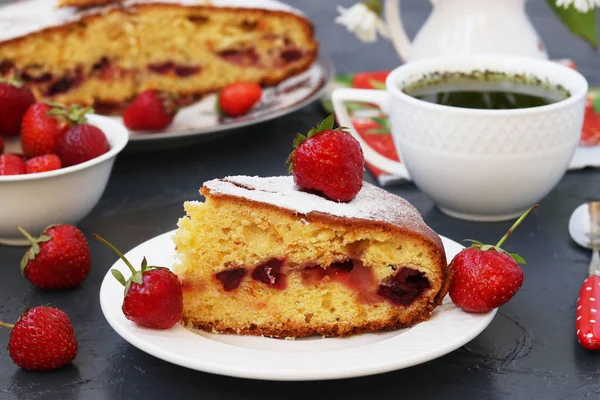 Домашний клубничный пирог расположен на темном фоне на белой тарелке — стоковое фото