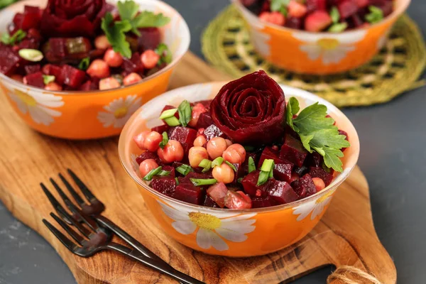 Lean chickpea and beetroot salad on a wooden board against a dark background, decorated with beetroot roses — Stock Photo, Image