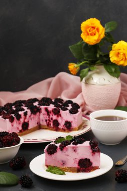 Böğürtlen ile pişirme olmadan cheesecake karanlık bir arka plan üzerinde yer alır