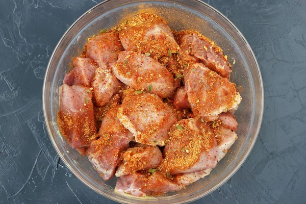 Pork meat cut into large pieces for shish kebab with spices in a transparent bowl — Stock Photo, Image