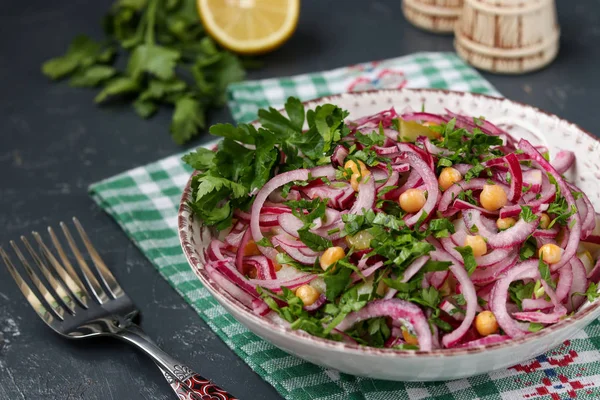 Здоровий салат з нутом, картоплею, червоною цибулею та маринованими огірками в тарілці — стокове фото