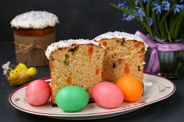 Easter cakes and colorful eggs are located on a plate on a dark background — Stock Photo, Image