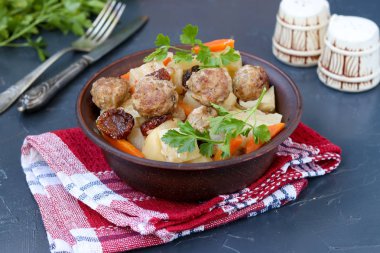 Haşlanmış patates köfte, havuç ve güneş kurutulmuş domates bir kase karanlık bir arka plana karşı