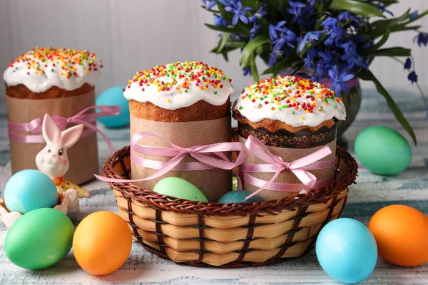 Пасхальні торти і барвисті яйця для яскравого весняного свята в плетеному кошику — стокове фото