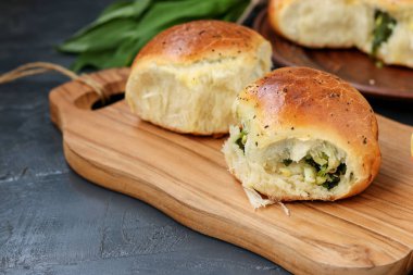 Yeşillik ve haşlanmış yumurta ile dolu Maya çörekler ahşap bir tahta üzerinde yer almaktadır