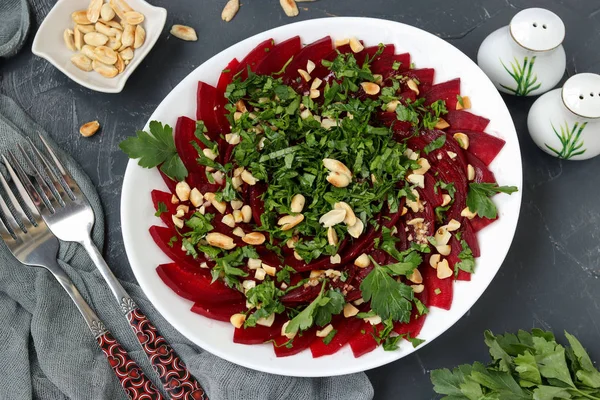 Healthy beetroot salad with peanuts and parsley on a white plate — Stock Photo, Image