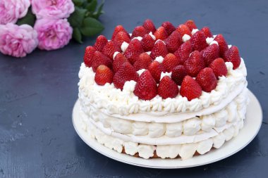 Çilek ve krem şanti ile Kek Pavlova, koyu bir arka plan üzerinde bulunan, yatay