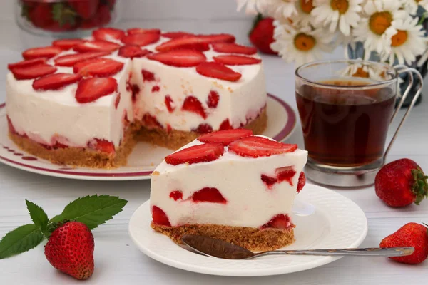 Pastel con fresas sin hornear situado en un plato sobre un fondo blanco — Foto de Stock