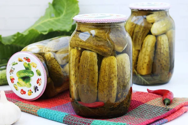 Marinated cucumbers in jars on a white background — Stock Photo, Image