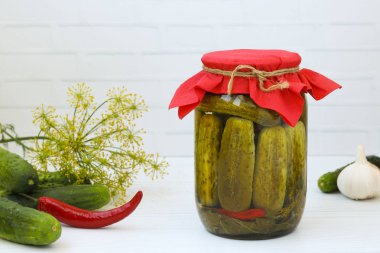 Beyaz bir arka plan üzerinde kavanozlarda marine salatalık, yazıt için ücretsiz bir yer