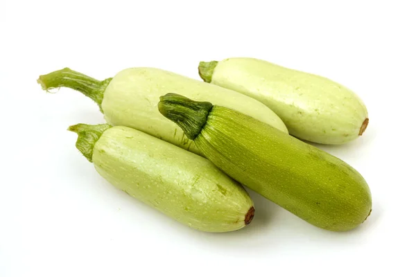 Zucchine disposte su sfondo bianco in ordine casuale, vista dall'alto — Foto Stock