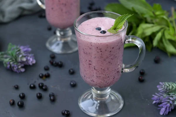 Nutritious cocktail with yogurt and blueberries located in glasses on a dark background — Stock Photo, Image