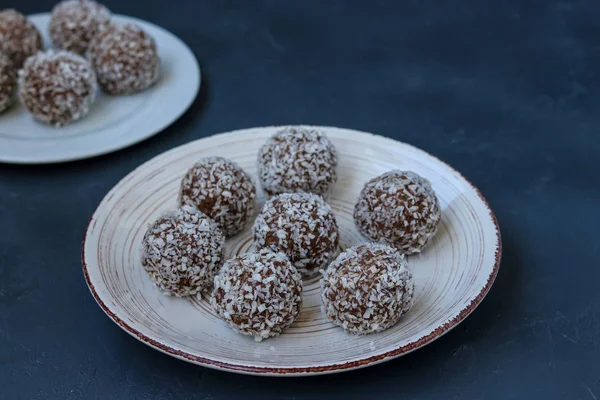 Творожные шарики с кокосовой стружкой и шоколадное печенье re расположен на темном фоне, горизонтальный — стоковое фото