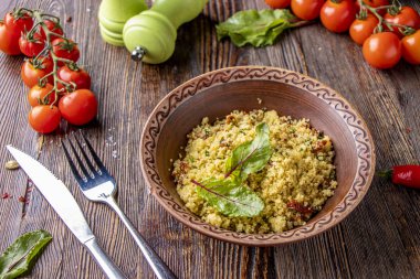 Ahşap arka plan üzerinde zeytinyağı ve kurutulmuş domates ile kasede kuskus, oryantal mutfağı, yatay fotoğraf