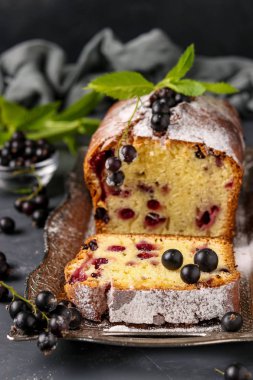 Siyah frenk üzümü cupcake koyu bir arka plan, dikey fotoğraf karşı bir tepsi üzerinde bulunan