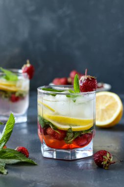 Çilek, limon dilimleri ve nane ile soğuk çilek mojito içecek, dikey fotoğraf