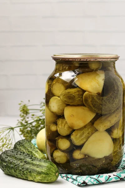 Marinated cucumbers with apples in jar are arranged on a white background, Harvest for the winter, close-up, vertical photo — Stock Photo, Image