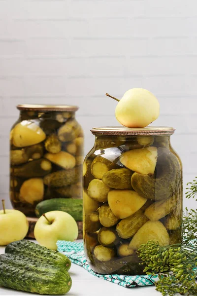 Marinated cucumbers with tomatoes are located in glass jars on a white background, Harvest for the winter, close-up, horizontal photo — Stock Photo, Image