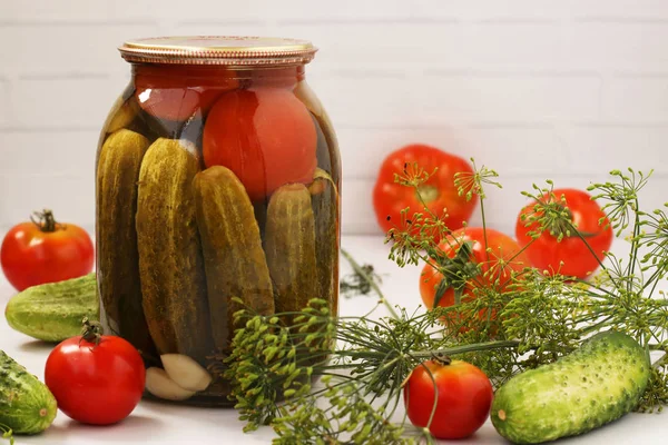 Marinated cucumbers with tomatoes are located in glass jars on a white background, Harvest for the winter, close-up, horizontal photo — Stock Photo, Image
