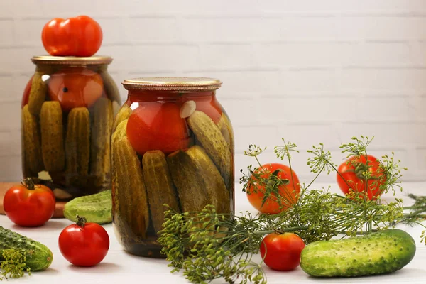 Marinated cucumbers with tomatoes are located in glass jars on a white background, Harvest for the winter, horizontal photo, copy space — Stock Photo, Image
