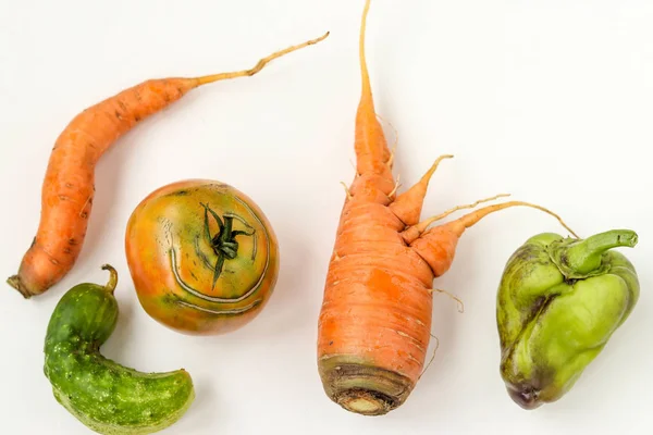 Cinco verduras feas: zanahorias, pepino, pimientos y tomates sobre fondo blanco, concepto de comida fea, foto horizontal, vista superior — Foto de Stock