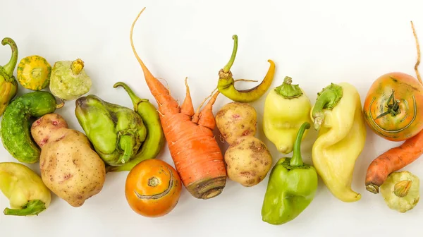 Μοντέρνα άσχημα λαχανικά: πατάτες, καρότα, αγγούρι, πιπεριές και ντομάτες σε λευκό φόντο, αίσθηση άσχημου φαγητού, οριζόντιος προσανατολισμός — Φωτογραφία Αρχείου