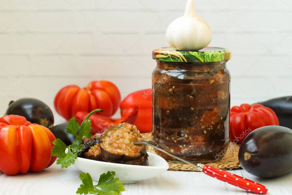 Eggplants in acute sauce of pepper, tomatoes and garlic in jar on the table, close-up, horizontal orientation, Harvesting vegetables for the winter