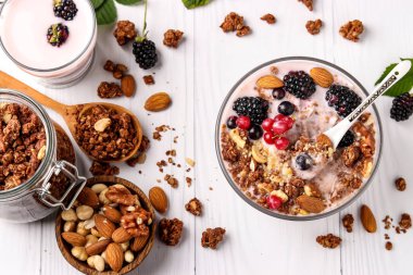 Doğal yoğurt, taze çilek, çikolata ve fındık ile Granola gevrek bal müsli hafif bir arka plan, sağlıklı gıda, yatay yönelim, üst görünümü karşı bir kase