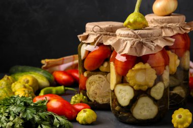 Çeşitli salatalık turşusu, patissons ve domates kavanoz larda koyu bir arka plan, yatay yönelim, kopya alanı
