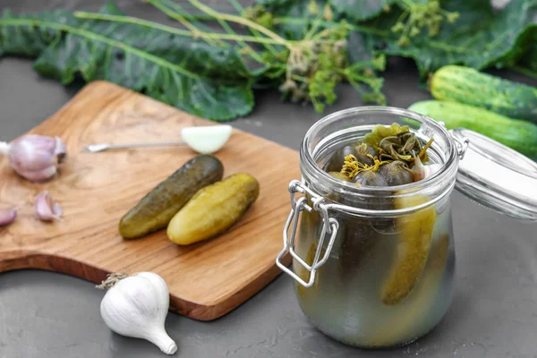 Pickles - pepinos fermentados enlatados en frasco de vidrio sobre fondo oscuro, orientación horizontal —  Fotos de Stock