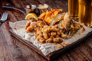 Set deniz ürünleri: midye, karides, küçük kızarmış deniz balığı, kraker ve soslar, genellikle bira ile servis edilir gıda, yatay oryantasyon