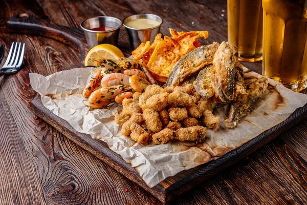 Set deniz ürünleri: midye, karides, küçük kızarmış deniz balığı, kraker ve soslar, genellikle bira ile servis edilir gıda, yatay oryantasyon