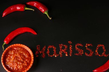 Koyu arka plan üzerinde Geleneksel Maghrebi acı biber biber sosu salça harissa, Tunus ve Arap mutfağı, yatay oryantasyon, Kuru biber kelime Harissa yazıt